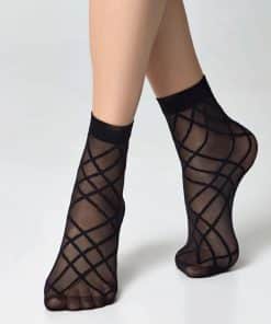 Ankles and feet wearing sheer black stockings with a bold diamond lattice pattern, cross-legged stance.