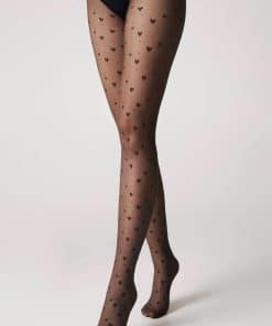 Legs in sheer tights with a black heart pattern, crossed ankles against a light background.