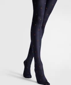 Navy tights with small brown polka dots on legs, model standing in a cross-legged pose.