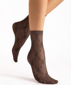 Brown sheer ankle socks with a floral lace pattern worn on a model's feet against a white background.